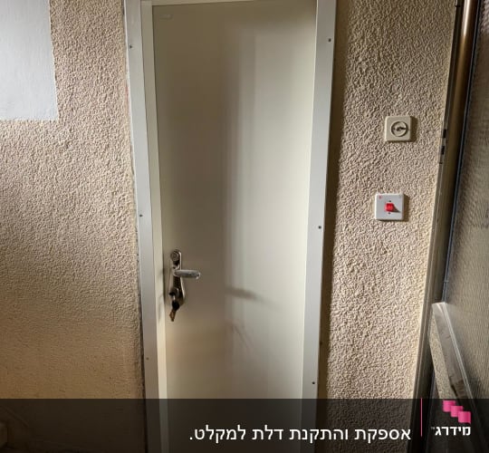 דלת לבנה עם ידית מתכת ומנעול תלוי